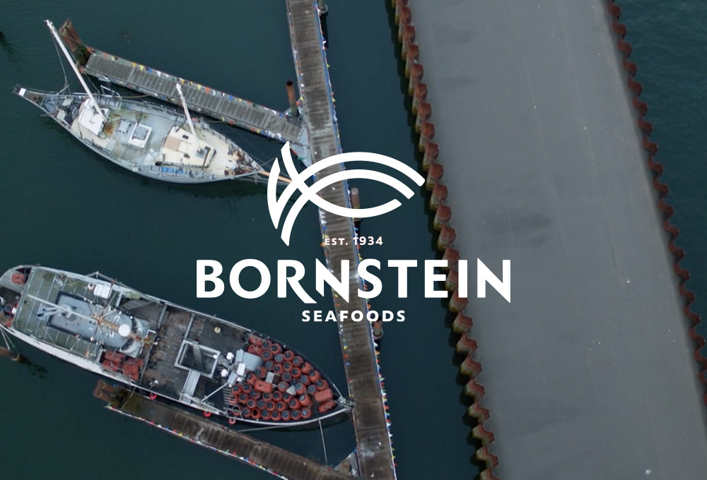 Bornstein Seafood logo over background with aerial view of docked boats