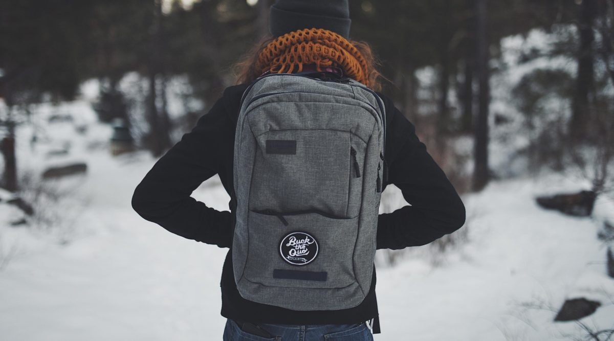 Girl wearing gray backpack with Buck the Quo patch
