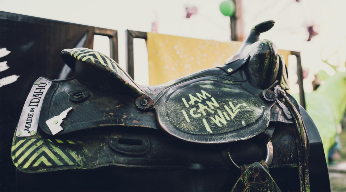Black saddle with I AM, I CAN, I WILL painted on it in yellow