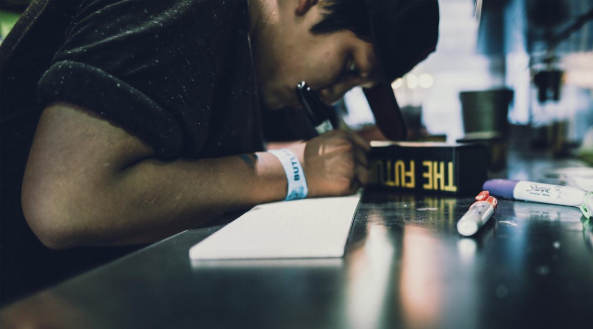 Teenager writing on wooden board