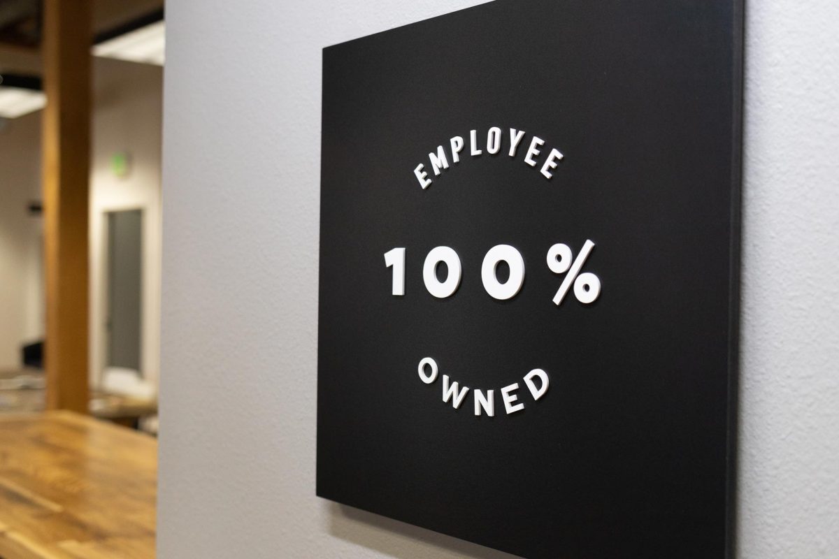 Black placard reading 100% Employee Owned in white lettering