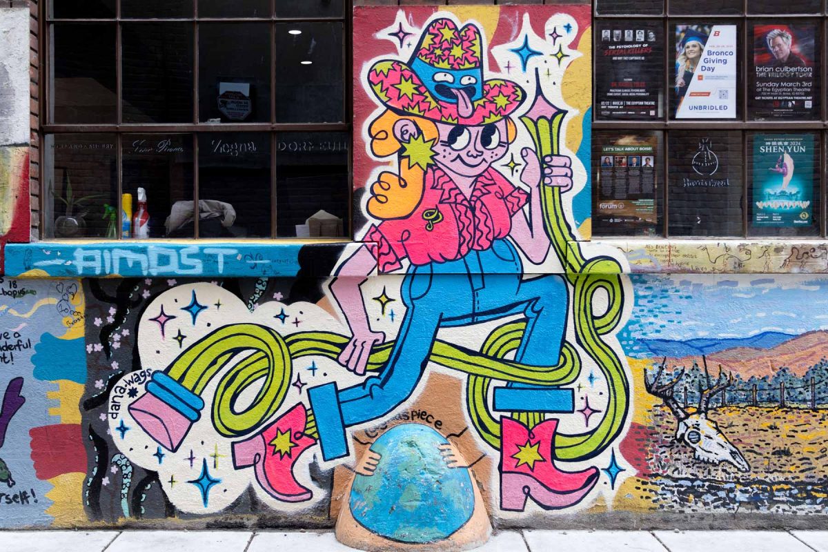 Mural showing a cowgirl in pink and blue walking wrapped up in a large flowing number two pencil